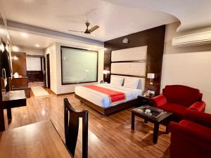 a hotel room with a bed and a red couch at INDRAPRASTHA RESORT And SPA - DALHOUSIE in Dalhousie