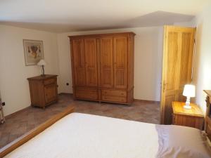マノスクにあるcampagne de pimayonのベッドルーム1室(ベッド1台付)、木製キャビネットが備わります。