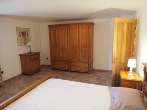 1 dormitorio con 1 cama y armario de madera en campagne de pimayon, en Manosque