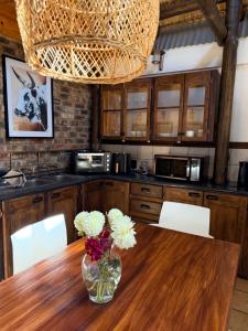 a kitchen with a wooden table with a vase of flowers at Bed In Bethlehem in Bethlehem