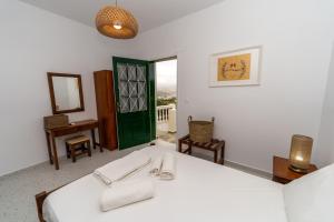 a room with a bed and a table and a mirror at Salla Chiotis in Karpathos