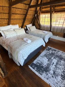 two beds in a room with wooden floors and windows at Bed In Bethlehem in Bethlehem