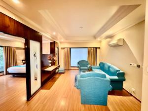 a living room with a blue couch and a bed at INDRAPRASTHA RESORT And SPA - DALHOUSIE in Dalhousie