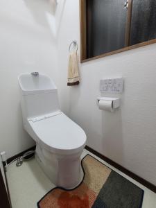 a bathroom with a white toilet in a room at Daizaifu Guest House 1 in Dazaifu