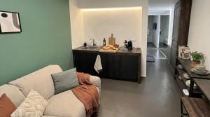 ein Wohnzimmer mit Sofa und eine Küche in der Unterkunft Mutina Suites in Modena + 10 Fotos