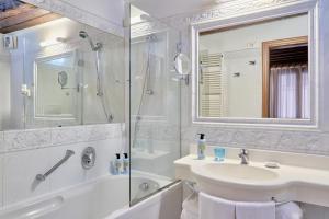 un bagno bianco con lavandino e doccia di Locanda Vivaldi a Venezia