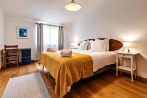 a bedroom with a large bed with a yellow blanket at FreeSurfCamp in Peniche