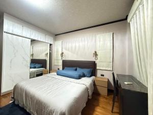 a bedroom with a large bed with blue pillows at Sufficient House in Nong Prue