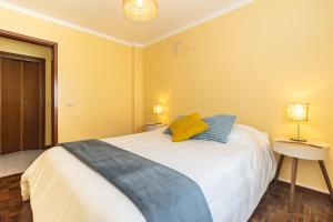 a bedroom with a large white bed with two blue pillows at Coast 2 Bedroom Apart Setúbal 45 min from Lisbon in Setúbal
