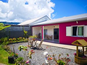 a red house with a patio and a garden at La Kaz 57 - Maison avec jacuzzi et sauna - La Réunion in La Plaine des Palmistes