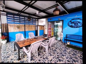 a dining room with a wooden table and white chairs at Turtle Nest in Hua Hin