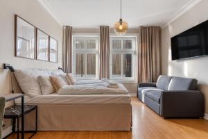 ein Schlafzimmer mit einem Bett, einer Couch und einem Stuhl in der Unterkunft Strandgata Hotel in Haugesund