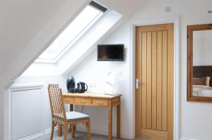 a room with a desk and a skylight at Hadrians Hotel in Chesters