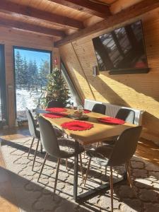 a dining room with a wooden table and chairs at The Retreat Marisel in Mărişel