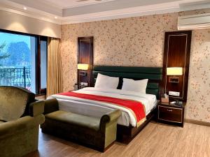 a bedroom with a bed and a chair and a window at INDRAPRASTHA RESORT And SPA - DALHOUSIE in Dalhousie