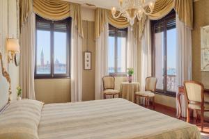una camera da letto con un grande letto e alcune finestre di Locanda Vivaldi a Venezia