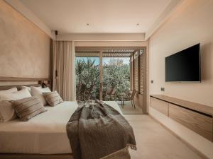 a bedroom with a large bed with a television on the wall at Mitsis Bali Paradise in Bali
