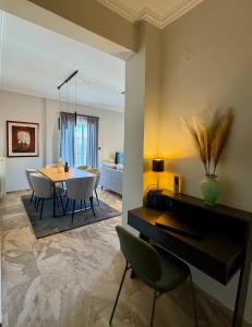 a dining room and living room with a table and chairs at B2 Pausilipon Park Corner in Karditsa