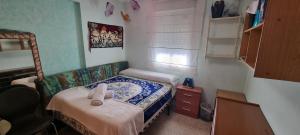 a small bedroom with a small bed and a table at Apto Templo de Isis, Habitación Verde en Amate in Seville