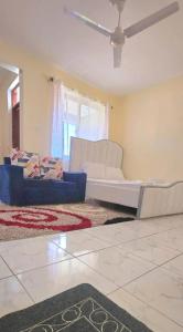 a living room with couches and a ceiling fan at The Great Stay Mtwapa in Mtwapa