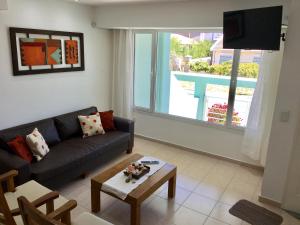 una sala de estar con un sofá y una mesa en Triplex Somuncura, en Las Grutas