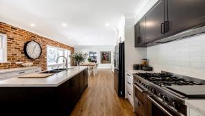 a kitchen with a clock on a brick wall at Nirvana Estate Macmasters Beach in Macmasters Beach