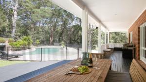 a porch with a table and a view of a pool at Nirvana Estate Macmasters Beach in Macmasters Beach