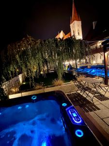 a hot tub with blue lights in front of a building at Penzion Kaplanka in Znojmo