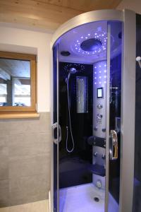 a bathroom with a shower with a glass door at Großglockner Goldried Chalet in Kals am Großglockner