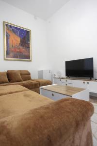 a living room with two couches and a flat screen tv at Villa Korzo in Bitola