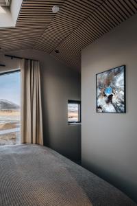 a bedroom with a bed with two pictures on the wall at Green Geysir Cottage in Torfastaðir