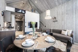 a dining room with a table and a couch at North Suite Eclipse 15A by Hilla Villas in Kittilä +42 photos