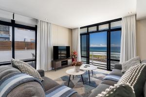 a living room with a couch and a television at 167 Eden on the Bay in Big Bay