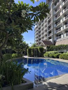 a large swimming pool in front of a building at Alea Residences 1 Bedroom Condo with Pool View Balcony in Manila