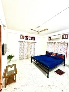 a bedroom with a blue bed and a table at Puspalay Homestay in Guwahati