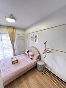 a bedroom with a bed and a lamp at Alea Residences 1 Bedroom Condo with Pool View Balcony in Manila +21 photos
