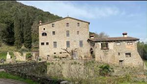 an old stone building on a hill with a wall at Mas Costa in Sant Ferriol