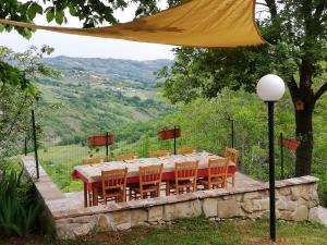 a dining table with chairs and a yellow umbrella at La Vecchia Fontana in Penne