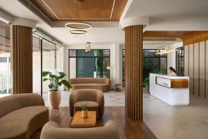 a lobby with couches and chairs and a counter at CASTELO Inn in Nedumbassery