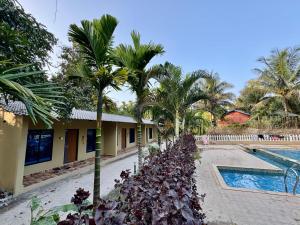 a resort with a swimming pool and palm trees at Dandeli River Valley Resort in Dandeli