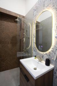 a bathroom with a sink and a shower with a mirror at Villa Korzo in Bitola +35 photos