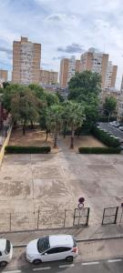 a white car parked in a parking lot in a city at Apto Templo de Isis, Habitación Verde en Amate in Seville