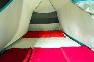 a red and white bed in a tent at Dandeli River Valley Resort in Dandeli