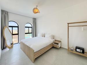 a white bedroom with a bed and a window at Butterwave | 1BR Jacuzzi & Terrace in Kfar Aabida in Fad‘ūs +100 photos