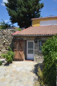 un edificio de piedra con una puerta y una pared de piedra en Casa Rural Almanzor, en Navarredonda de Gredos