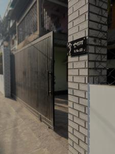 a gate in a brick building with a sign on it at Puspalay Homestay in Guwahati