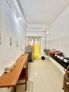 a kitchen with a wooden table in a room at Puspalay Homestay in Guwahati