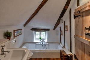 a bathroom with a bath tub and a sink at Finest Retreats - Syncocks Farm Cottage in Petrockstow +31 photos