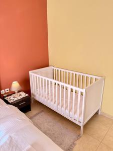 a white crib in a room with a bed at Apartment Mitrou in Loutra Oraias Elenis