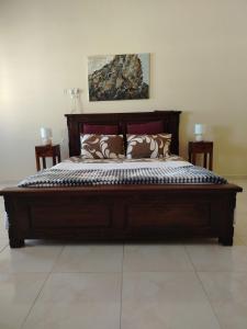 a large wooden bed with pillows on it in a bedroom at Bustan Shells House in Muscat